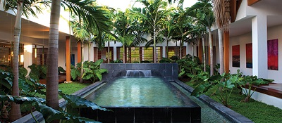 tropical swimming pool with rows of palms and philodendron plantings to reduce echo by LAND ART Landscape Architecture